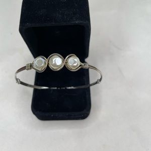 Ronaldo, silver wire with three pearl colored white stones.